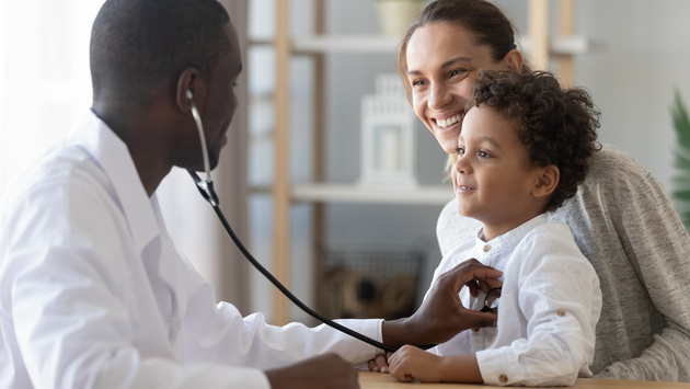 Friendly doctor checking a happy kid and mom. 